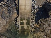 a couple of boats are in the water near rocks and waterwalls as seen from above