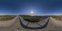 360 - view photograph of path and sand dunes near ocean with blue sky in the background