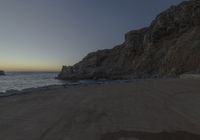 there are rocks and the water by the beach at sunset time at this area of town