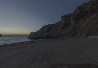 there are rocks and the water by the beach at sunset time at this area of town