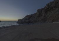 there are rocks and the water by the beach at sunset time at this area of town