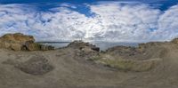 a landscape of rocks and sand with the sky in the background that is 360 degrees