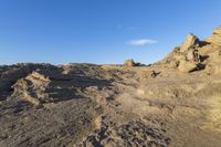 a beach and rocky outcropping next to the ocean and sky with an airplane flying