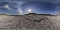 the view of a sand dune and the ocean from a fisheye lens, on a sandy beach