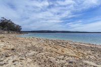 the sandy beach is full of rocks and gravels and a blue ocean has clear water