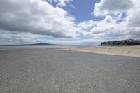 a view of a sandy beach, the tide is crashing and the shore is still dry