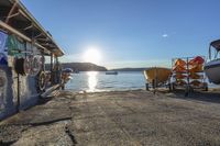 a small boat is tied up to a dock with two boats and a cart with some boats in it