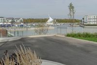 a city view across a lake and boats moored at dock and trees are in the background