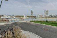 a city view across a lake and boats moored at dock and trees are in the background