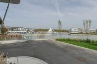 a city view across a lake and boats moored at dock and trees are in the background