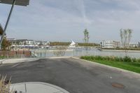 a city view across a lake and boats moored at dock and trees are in the background