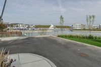 a city view across a lake and boats moored at dock and trees are in the background