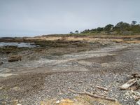 a sandy beach area with cliffs and a small body of water near the shore line