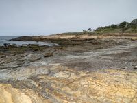 a sandy beach area with cliffs and a small body of water near the shore line