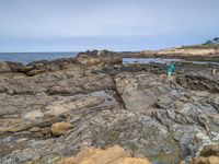 a sandy beach area with cliffs and a small body of water near the shore line