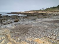 a sandy beach area with cliffs and a small body of water near the shore line