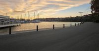 view of a marina with boats in the harbor during sunset and the sun rising up