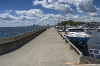 the boats are docked at the pier as the city walks away from them in the distance