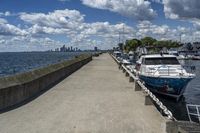 the boats are docked at the pier as the city walks away from them in the distance