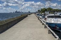 the boats are docked at the pier as the city walks away from them in the distance