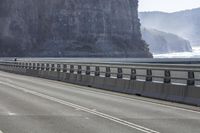 a long highway that has a boat coming up it's side with mountains in the background