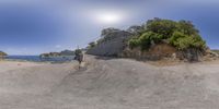 a motorcycle on a mountain with water in the background in this panorama fish eye view