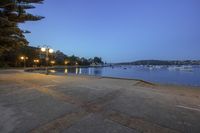 the view from a park bench, of boats anchored in a bay and buildings on the shore