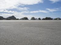 a lone skateboarder is seen in the background while skating on a flat surface