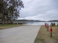 a park with a picnic table, benches, and trees at the edge of a lake