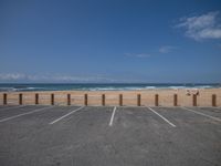 a parking lot has some empty seats and stands on the beach in front of it