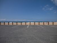 a parking lot has some empty seats and stands on the beach in front of it