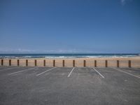 a parking lot has some empty seats and stands on the beach in front of it