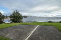 a parking lot in front of a body of water, with the ocean in the background