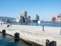 some dock and water and some buildings with people in it in the background and mountains