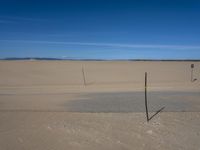 a paved beach with a fence in front of it and the ocean in the distance