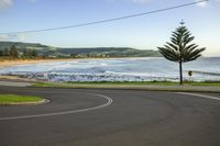 a curve on the road by the beach as it is curved toward the water's edge