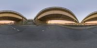 a view of two oval shaped bridge on a road at sunset while viewed from below