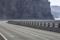 a long highway that has a boat coming up it's side with mountains in the background