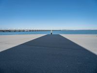 a shadow of the wall that's made into a dock with some boats in the water