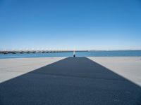 a shadow of the wall that's made into a dock with some boats in the water