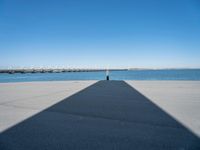 a shadow of the wall that's made into a dock with some boats in the water