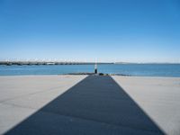 a shadow of the wall that's made into a dock with some boats in the water