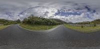 a fish eye lens on the road in front of a fenced area and hills