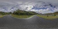 a fish eye lens on the road in front of a fenced area and hills