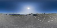 several cars parked along side a road and some cars and trucks in the parking lot