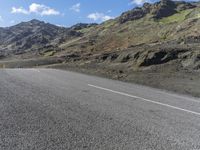 a small child is sitting on a motorcycle in the middle of a road next to some mountains