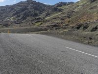 a small child is sitting on a motorcycle in the middle of a road next to some mountains