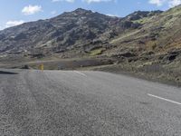 a small child is sitting on a motorcycle in the middle of a road next to some mountains