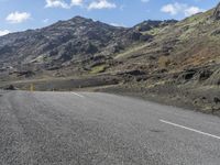 a small child is sitting on a motorcycle in the middle of a road next to some mountains