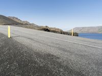 there is a bicycle on the side of a road that has been paved with a yellow pole